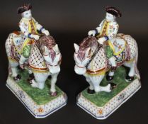 A pair of 19th Century French tin glazed earthenware figures of men in 18th Century dress riding