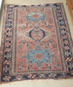 A Persian rug, the three central medallions in dark blue, salmon,