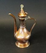 A 19th Century Turkish copper coffee pot with a small brass finial star enclosed by crescent moon,
