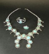 A suite of Native American made white metal and turquoise squash blossom jewellery including