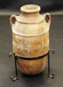 A Greek terracotta amphora with two ribbed bands united by the side handles over a plain body,