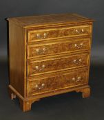 A burr walnut and cross banded chest of four long graduated drawers on bracket feet,