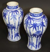 A pair of 19th Century Chinese slender baluster shaped vases, underglaze decorated with blue