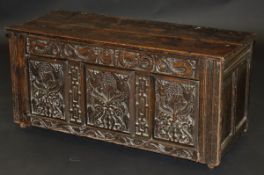 A 17th Century Welsh oak coffer, the later two plank top over a stylised dragon/serpent decorated