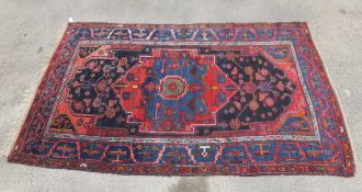 A Caucasian rug, the central medallion in red, blue,