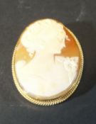 A 9 carat gold mounted shell cameo brooch decorated with bust of a young lady with ribbon in her