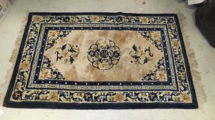 A Chinese rug, the central circular medallion in dark blue, mid blue,