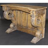 A Victorian Gothic Revival oak console table with heavily carved decoration of grapes on vine and