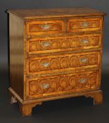 A yew wood and inlaid chest of two short and three long graduated drawers with brass handles and
