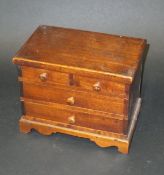 A Victorian mahogany miniature chest of two short and two long drawers with turned wooden handles,