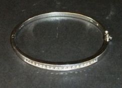 A 9 carat white gold bangle set with 20 small diamonds, approx 0.