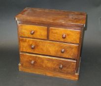 A Victorian mahogany miniature chest of two short and two long drawers with turned knob handles,