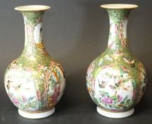 A pair of circa 1900 Chinese Canton famille-rose vases of onion form with flared rims, decorated