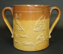 An over-sized 19th Century salt-glazed loving mug decorated in relief with stag-hunting scene and