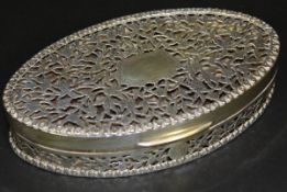 A George V silver dressing table box of oval form with pierced foliate decoration (by S.