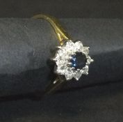 An 18 carat gold mounted sapphire and diamond cluster ring, the centre stone approx 0.