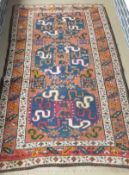 A Caucasian rug, the three central medallions decorated in blue, salmon,