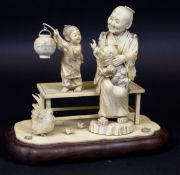 A 19th Century Japanese Meiji period okimono as a grandmother and children upon a bench with