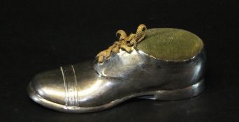 An Edwardian novelty silver pin cushion as a gentleman's shoe, the wooden base stamped "Fisher,