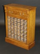 An oak and burr walnut decorated wine rack, the single drawer above rack to a plinth base,