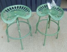 A pair of green painted metal stools in the form of tractor seats*