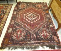 A Caucasian rug, the central diamond shaped medallion in cream and dark red,