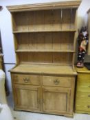 A Victorian pine dresser, the two tier boarded plate rack over two drawers and two cupboard doors,