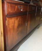 A modern mahogany sideboard with three drawers over three doors,