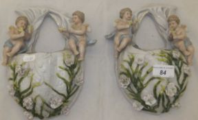 A pair of circa 1900 Continental porcelain cherub decorated wall pockets