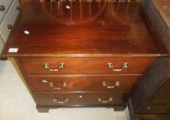 A mahogany chest of three long drawers with brass swing handles
