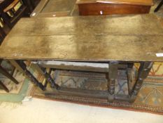 An 18th Century oak oval gateleg drop leaf dining table on turned supports to block feet united by