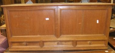 An early 20th Century teak hanging cabinet with two panels over three drawers,