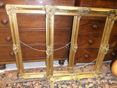 A pair of modern swept gilt framed picture / mirror frames