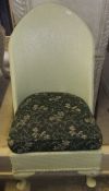 A Lloyd Loom style pale green painted chair with dark green upholstered cushion