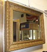 A large modern gilt decorated wall mirror and another 19th Century gilt rectangular wall mirror