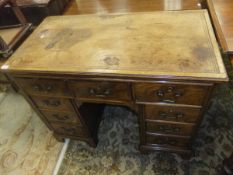An early 20th Century walnut double pedestal desk in the 18th Century manner, the top with tooled