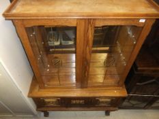 A Dutch style display cabinet with two glazed doors on a base of two cupboard doors to turned legs