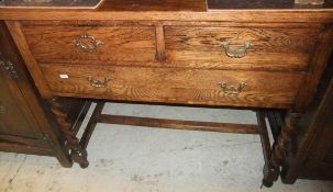 An early 20th Century oak side table with two short over one long drawer on barley-twist supports