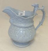 A 19th Century blue glazed relief moulded jug with mask head decoration and the handle with dog's