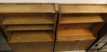 A two section pine bookcases with various adjustable shelves over two pairs of twin cupboard doors