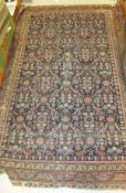 A Persian rug with all over stylised floral and foliate decoration in terracotta,