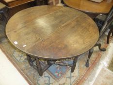 A 19th Century oak oval gateleg drop leaf dining table on turned supports to block feet united by