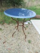 A blue ceramic topped garden table on iron base