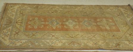 A Caucasian carpet, the central diamond and floral decorated medallions in cream, pale green,