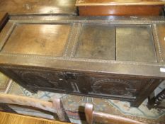 An 18th Century oak coffer, the rising top over two arch carved panels,