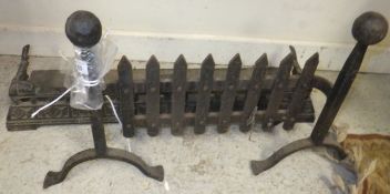 A small cast iron fender and a set of wrought iron fire dogs with integral guard (2)