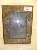 A modern silver photo frame with scrolling floral design (London 1994)