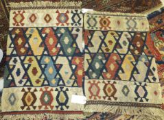 Two small Kelim rugs in shades of cream, terracotta, pale gold, pale orange, green and blue,