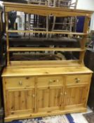 A pine dresser of two shelves over three drawers and three cupboard doors,