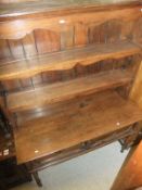 An oak dresser with three shelves above two shelves above two drawers, raised on turned legs,